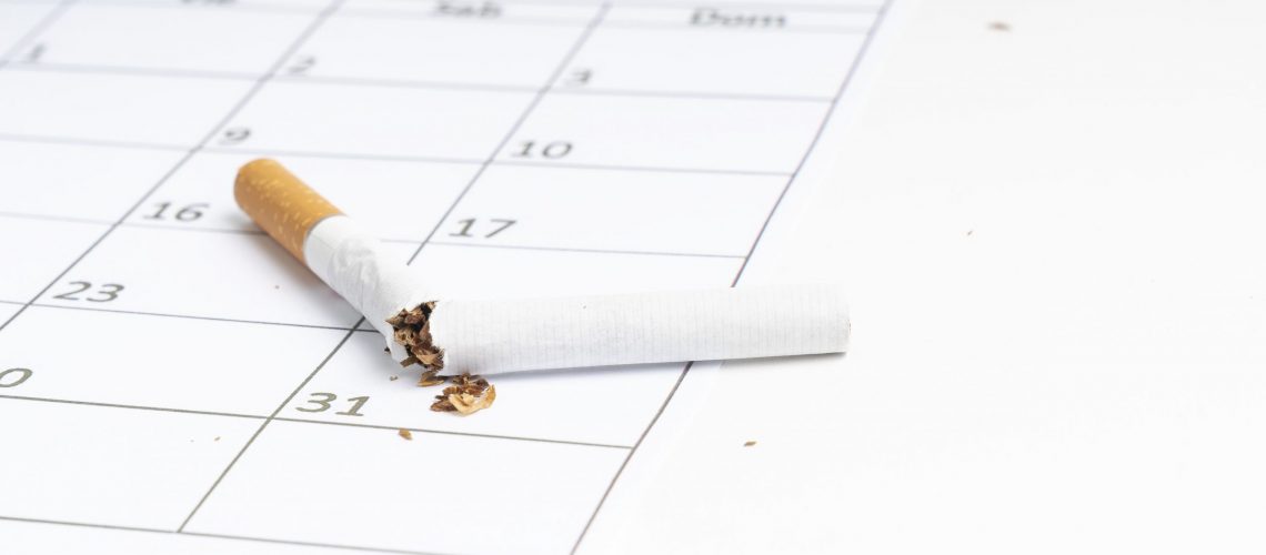 Broken cigarette on a calendar marking International No Tobacco Day with white background